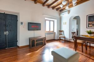 a living room with a table and a tv on a wall at VG PIAZZA DEL POPOLO 5 STELLE Appartamento Elegante in Rome