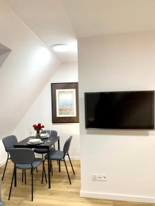 a dining room with a table and chairs and a television on a wall at Hotel, Apartament Pod Złotym Lwem w samym centrum miasta z DARMOWYM parkingiem VII in Kłodzko