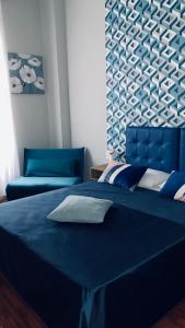 - une chambre avec un lit bleu et une tête de lit bleue dans l'établissement Carpe Diem Vaticano, à Rome