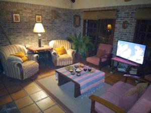 a living room with chairs and a table and a tv at Posada 5a. Reverie in Cuchilla Alta