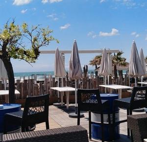 カップ・ダグドにあるAGREABLE STUDIO VUE PORT AU CAP D'AGDEのパティオ(テーブル、白いパラソル付)