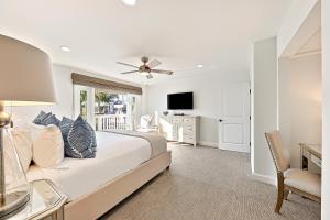 a bedroom with a bed and a television and a chair at Balboa Island Diamond Resort Compound in Newport Beach