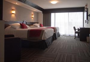 a hotel room with two beds and a window at Ramada Plaza by Wyndham Leon in León