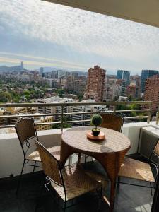 un tavolo e sedie su un balcone con vista sulla città di Views Cordillera a Santiago