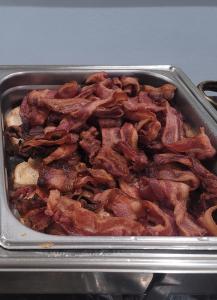a pan full of bacon in a pan at Vero Beach Inn & Suites Vero Beach I-95 in Vero Beach