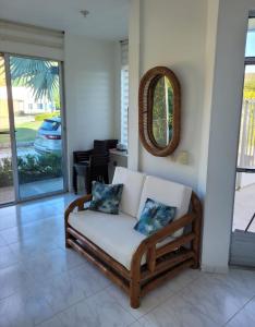 a couch sitting in a living room with a mirror at PRECIOSA CASA con Piscina, Jacuzzi y BBQ en Girardot in Girardot +17 photos
