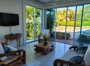 a living room with sliding glass doors and a tv at PRECIOSA CASA con Piscina, Jacuzzi y BBQ en Girardot in Girardot