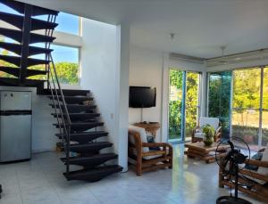 a living room with a spiral staircase and a television at PRECIOSA CASA con Piscina, Jacuzzi y BBQ en Girardot in Girardot