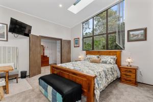 sypialnia z łóżkiem, oknem i biurkiem w obiekcie Westhay Stables - Paparoa Holiday Home w mieście Paparoa