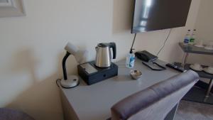 einen Schreibtisch mit Kaffeemaschine und Telefon in der Unterkunft The Saratoga in Waterford