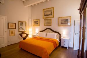a bedroom with a bed with an orange blanket at Borgo Pinti Suites Le Stanze dei Nobili in Florence