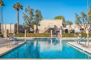 斯科茨代爾的住宿－Sweet Home Granada，一座拥有蓝色海水和棕榈树的游泳池