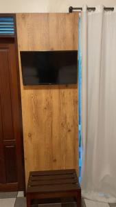 pared de madera con TV y banco de madera en Hotel Enseada de Ponta Negra, en Natal