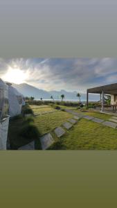een uitzicht op een veld met een paviljoen en de zonsondergang bij Igloo Glamping Bali in Kintamani