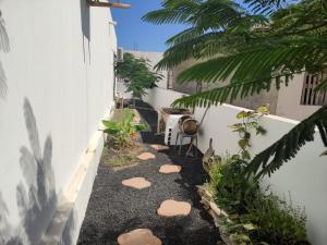 un jardín con rocas y plantas en el lateral de un edificio en Habitación en Casa Denube en Las Playitas