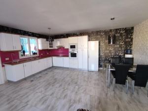 a kitchen with white cabinets and a table and chairs at Habitación en Casa Denube in Las Playas