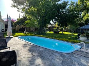 a swimming pool in a yard with a table and chairs at Finca del Rocio in Parras de la Fuente