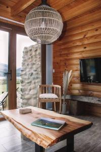 a living room with a table and a chandelier at Cabaña frente al lago Meliquina in Lago Meliquina