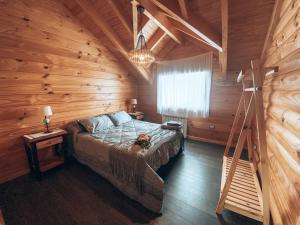 a bedroom with a bed in a wooden cabin at Cabaña frente al lago Meliquina in Lago Meliquina