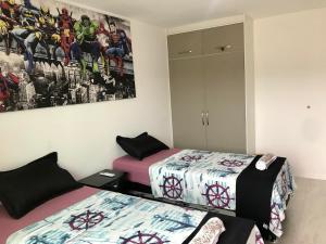 a room with two beds and a painting on the wall at Praia dos Anjos Residence Clube - O melhor de Arraial do Cabo in Arraial do Cabo +27 photos