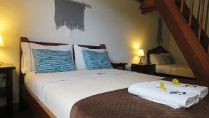 a bedroom with a bed with blue and white pillows at Ecohotel Bordones in Isnos