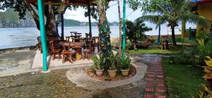 un patio con tavoli e sedie accanto all'acqua di Hadefe Cottages a El Nido