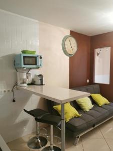 德爾錫倫西奧海岸的住宿－Apartment Chaparral，一张桌子,一张沙发,墙上挂着一个钟