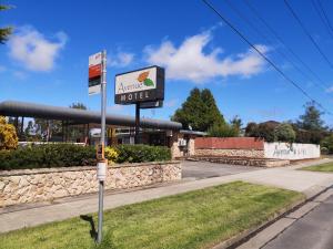 a sign in front of a motel with a parking meter at Avenue Motel in Ballarat