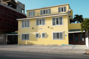 a yellow house on the side of a street at Andalucia Guest House in San Juan