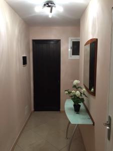 korytarz z czarnymi drzwiami i stołem z kwiatami w obiekcie Apartment Chaparral w mieście Costa Del Silencio