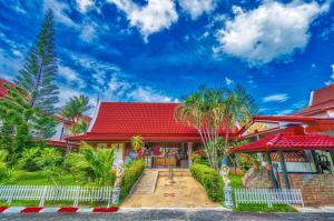 una casa con techo rojo y valla blanca en Sai Rougn Residence - SHA Extra Plus en Patong