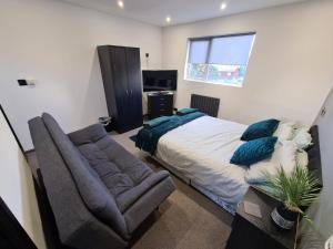 um quarto com uma cama, um sofá e uma janela em Oxclose studios em Peterborough