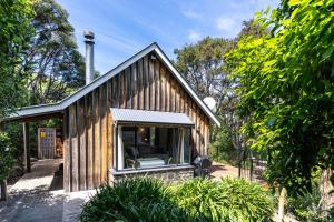 a house with a large window on the front of it at Woodside - Akaroa Holiday Cottage in Akaroa