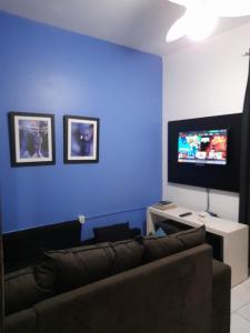 sala de estar con sofá y pared azul en Kasa Hostel Bar e Karaoke, en Balneário Camboriú