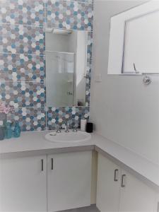 a bathroom with a sink and a mirror at Moondara Unit 2 21 Bulcock Beach Esplanade Bulcock Beach in Caloundra