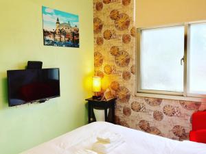 a bedroom with a bed and a flat screen tv at 夕說淡水民宿 in Tamsui