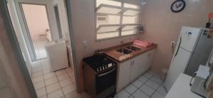 a small kitchen with a sink and a stove at Apto 304 - 1 quadra do mar e centro in Capão da Canoa +32 photos