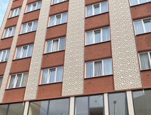 un grand bâtiment en briques avec de nombreuses fenêtres dans l'établissement Bursa Malkoc Hotel, à Bursa