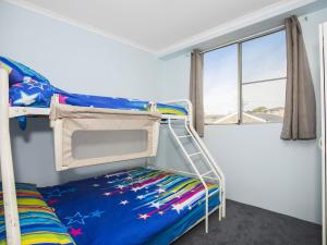 a bedroom with two bunk beds and a window at Fairleigh Unit 1 in The Entrance