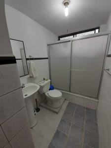 a bathroom with a toilet and a sink at Amplio y cómodo departamento. in Loja