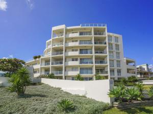 a tall white apartment building on the beach at Ocean Views Sundrift Unit 26 in The Entrance