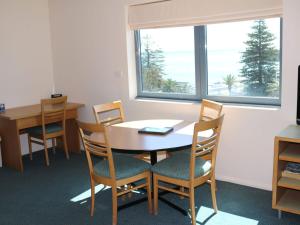 Un comedor con mesa y sillas y una ventana. en The Entrance Waterfront Resort Unit 502, en The Entrance