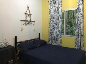 Schlafzimmer mit einem Bett und einem Fenster mit Vorhängen in der Unterkunft Soursop Hostel in Cueta + 34 Fotos