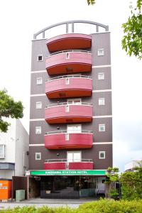 un edificio con balcones rojos y rojos. en Kakegawa Station Hotel, en Kakegawa