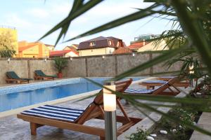 a pool with lounge chairs and a blue and white towel at Hotel Cristal in Mamaia Sat/Năvodari