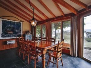 ein Esszimmer mit einem Holztisch und Stühlen in der Unterkunft Edzell Stunning Waterfront Home in Jindabyne