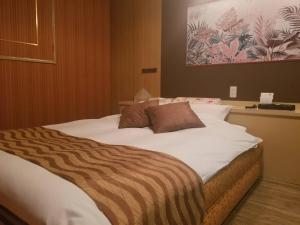 a large bed with a zebra blanket on top of it at ホテルLambie in Tōgane