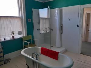 a bathroom with a bath tub and a shower at Grantham House in Ryde