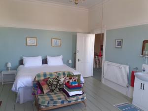 a bedroom with a bed and a chair with pillows at Grantham House in Ryde