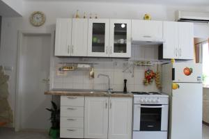 a kitchen with white cabinets and a sink and a refrigerator at Apartment Devivi Adris in Split